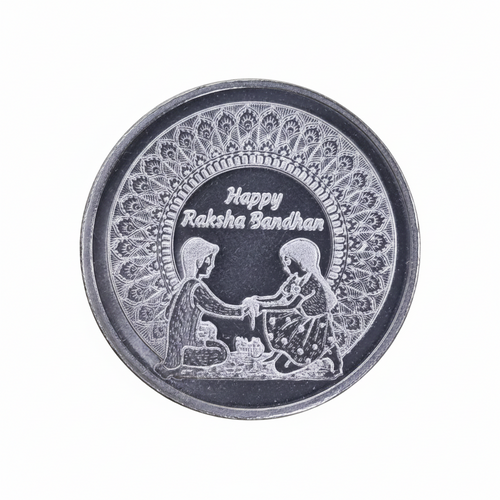 A round silver-toned metal token or button featuring an engraved design with two children holding hands, a floral pattern border, and the text 'Happy Rakha Bandhan' on a black center background.