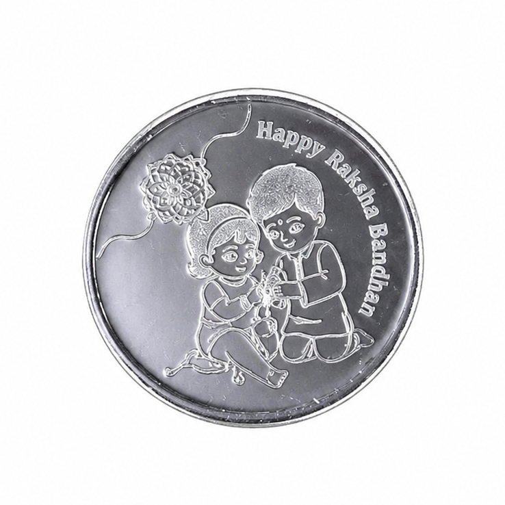 A round silver-toned coin or medallion with engraved illustrations of two children and the text 'Happy Rakhi Bandhan' on a plain white background.